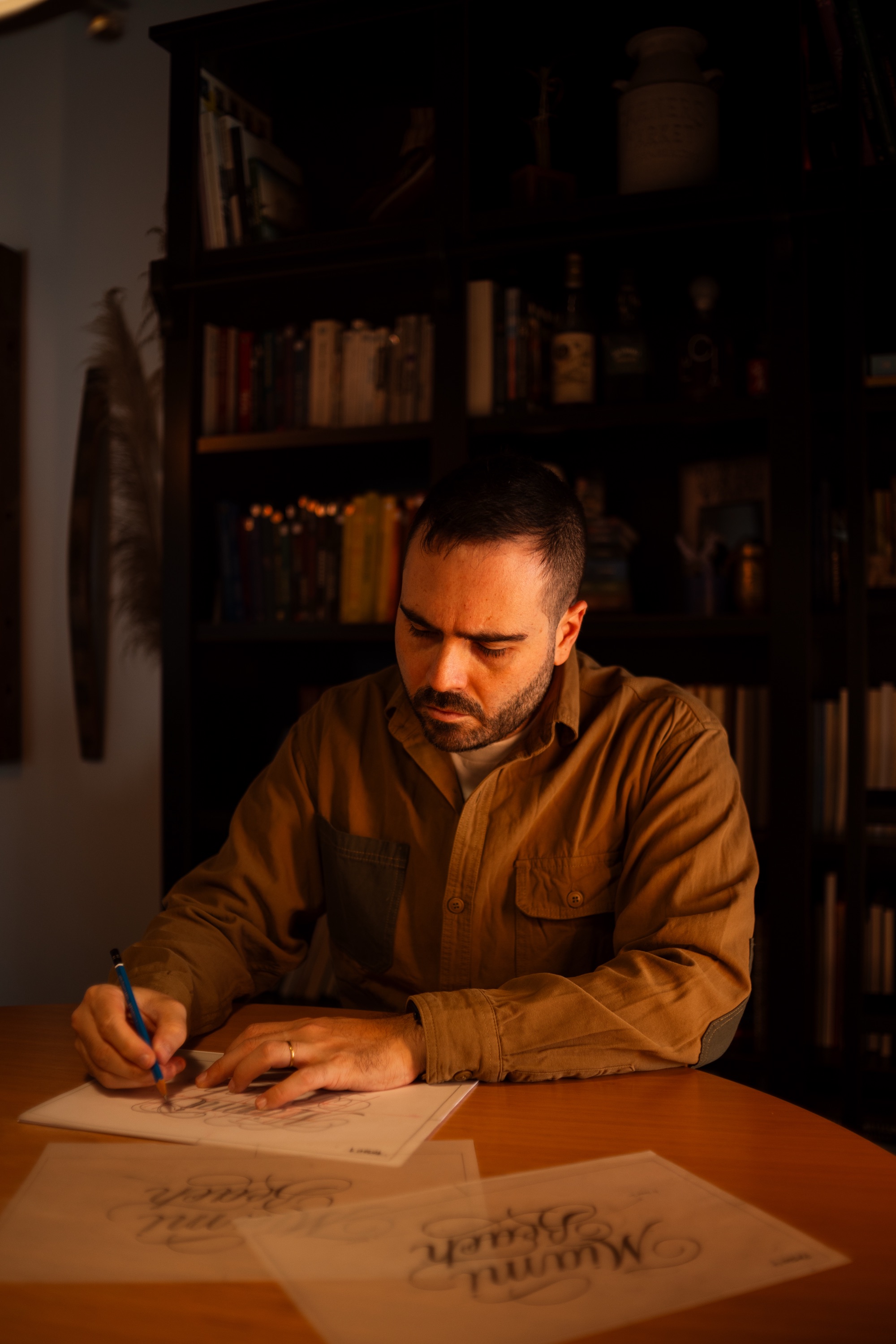 Victor Tognollo desenhando lettering à mão, no papel, no estúdio